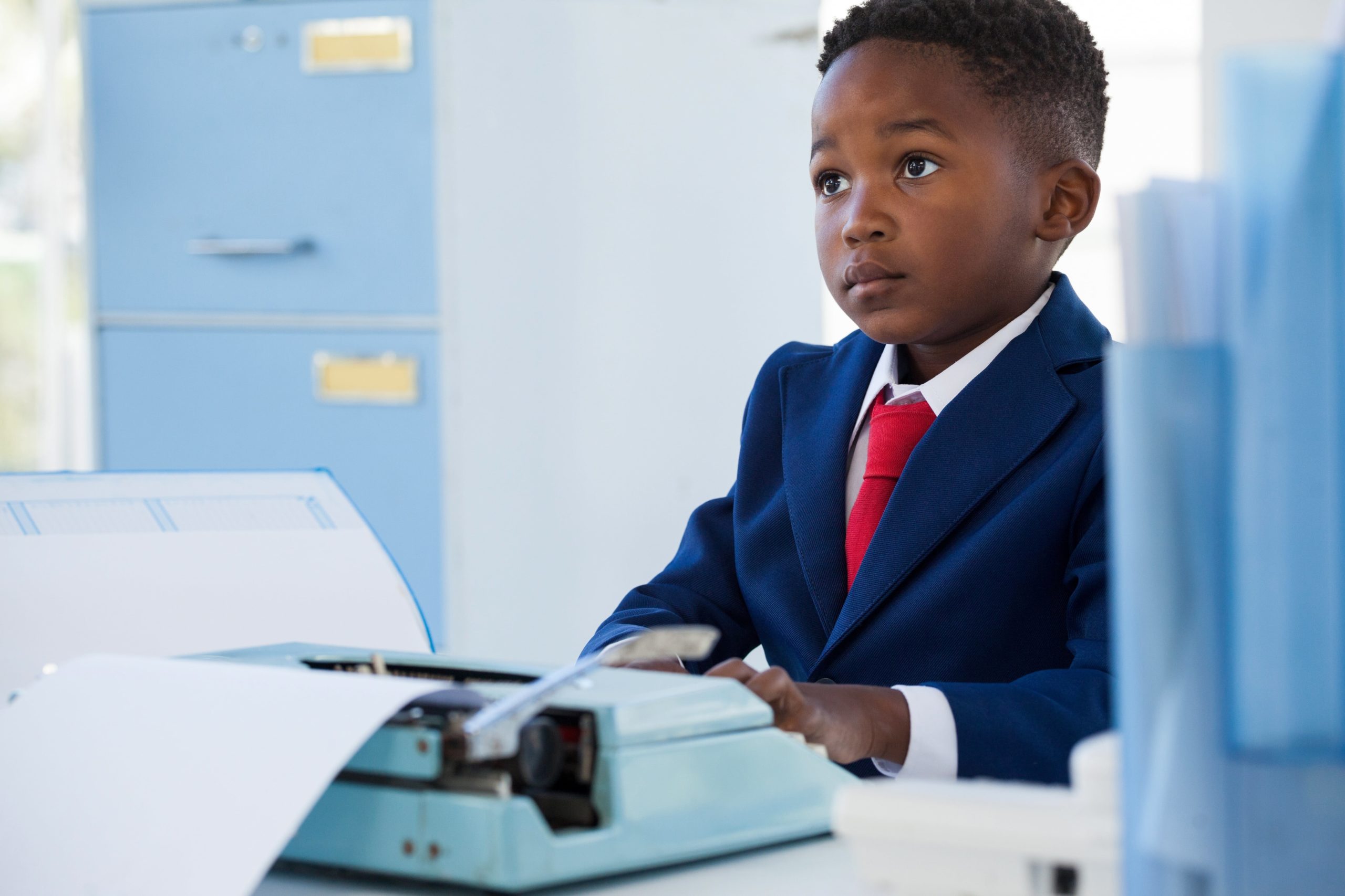 young boy in suit with typewriter